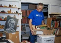 Waukegan Public Library Executive Director Richard Lee in Ray Bradbury's basement with a box of foreign editions.