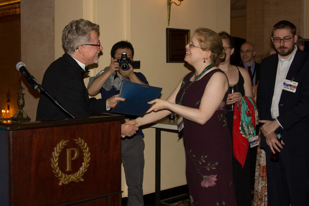 Katherine Addison (Sarah Monette)  receives her Nebula nominee certificate at a pre-banquet ceremony. Photo by Kathi Overton.
