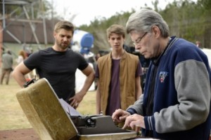 Stephen King at the typewriter, with Mike Vogel and Colin Ford.