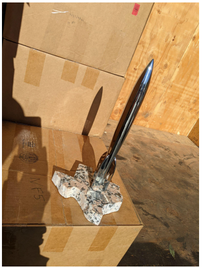 Color photo of 1997 Hugo Award trophy. Chrome-plated rocket on marble base shaped like the state of Texas